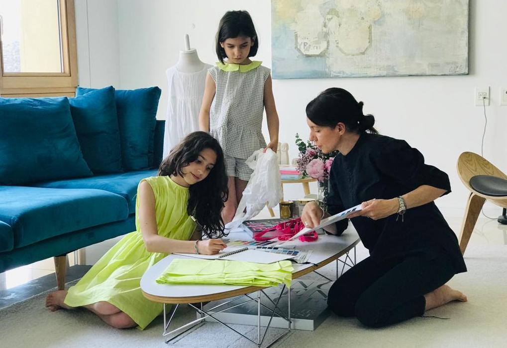 La stilista Emanuela Nurra, a destra, disegna gli abiti sotto lo sguardo attento delle figlie Emilia e Giulia