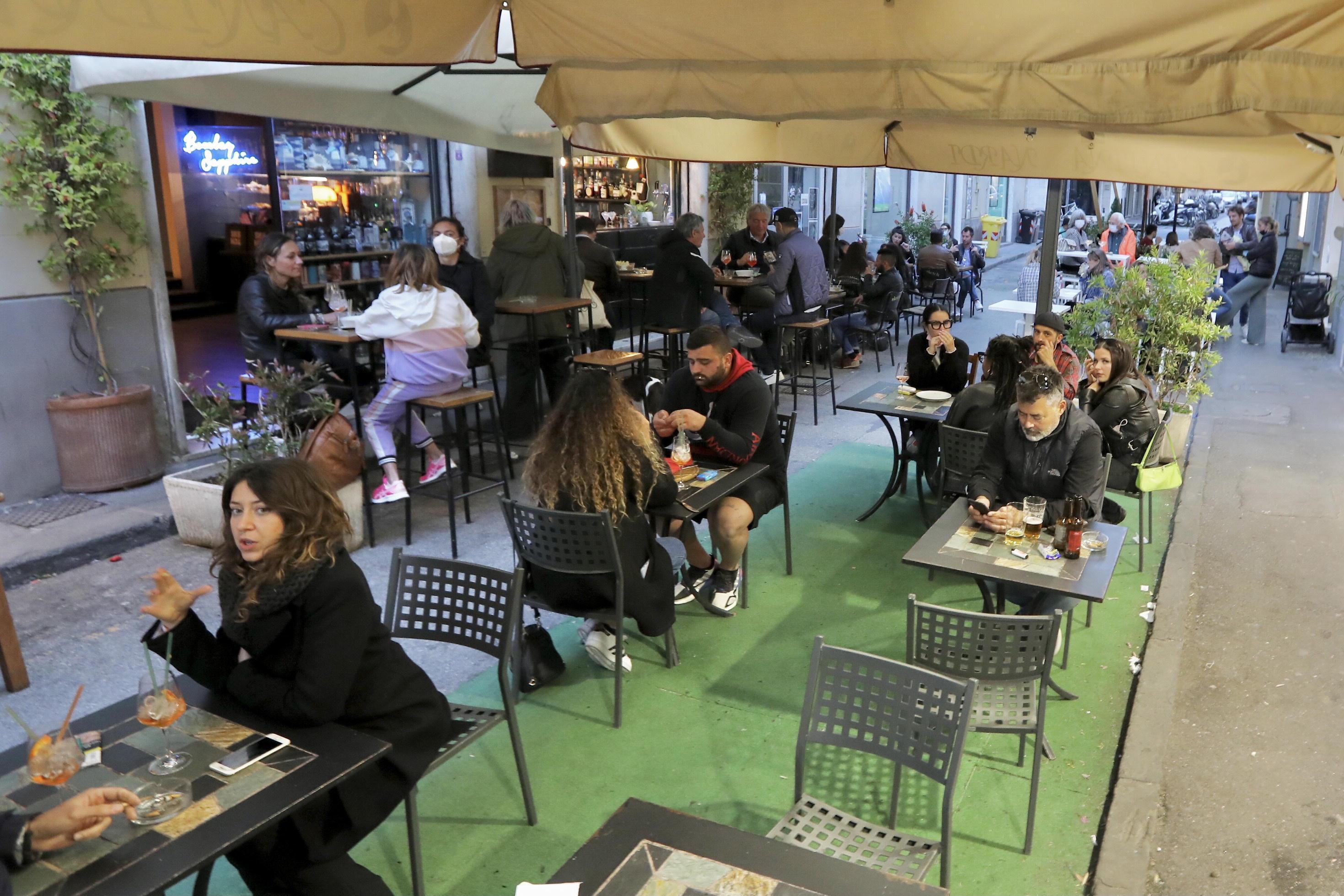 Tornano in via Cambini gli amanti dell’aperitivo: seduti al tavolo le persone si godono un bicchiere di vino in alto allo spazio esterno della Cantina Nardi