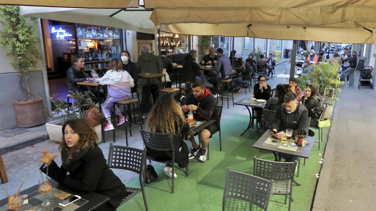 Tornano in via Cambini gli amanti dell’aperitivo: seduti al tavolo le persone si godono un bicchiere di vino in alto allo spazio esterno della Cantina Nardi