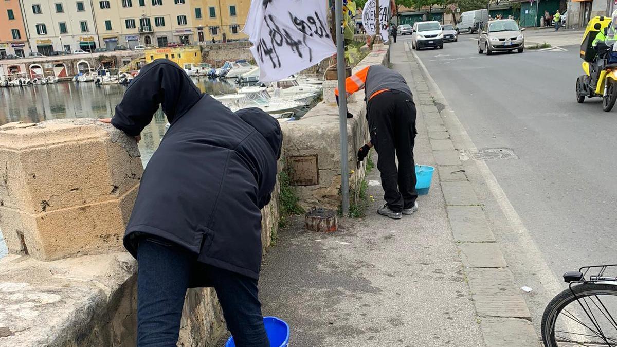 Alcuni esponenti della comunità tunisina mentre ripuliscono la spalletta