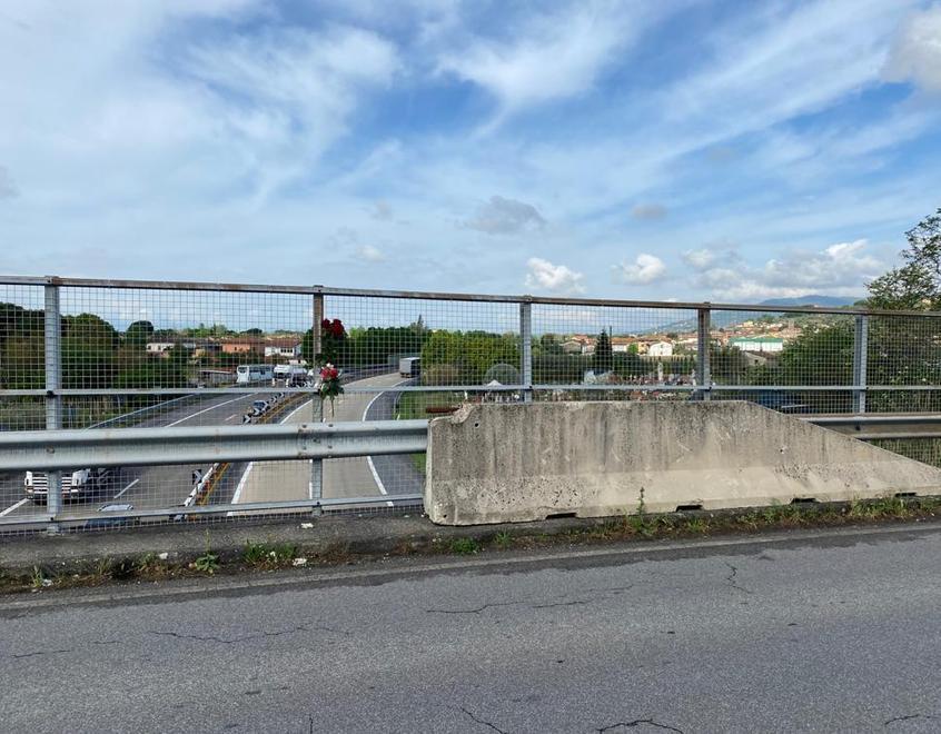 Il punto in cui la donna si è arrampicata per gettarsi sull’autostrada: accanto è appeso un mazzo di rose