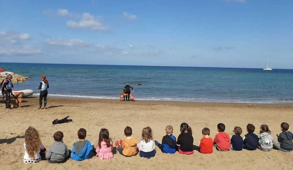 Cane bagnino in spiaggia Lezione di salvamento per i bimbi della materna