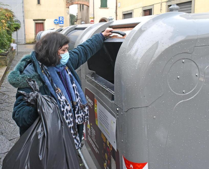Una utente getta un sacco di rifiuti in uno dei nuovi cassonetti installati in città da Alia (Foto Gori)