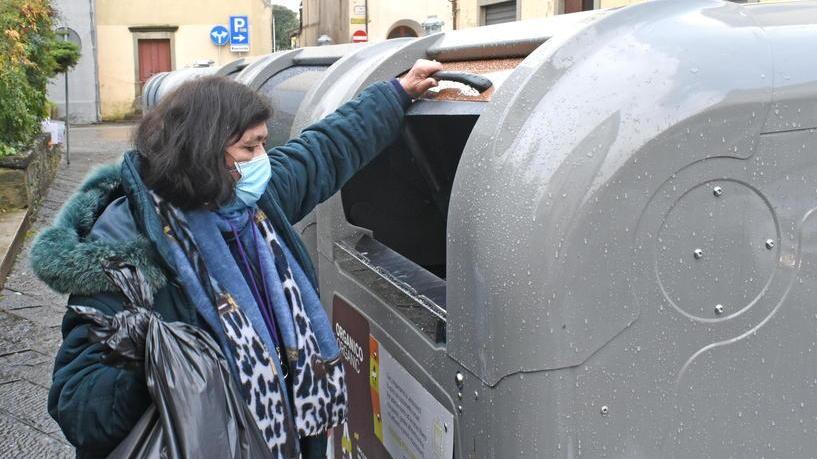 Una utente getta un sacco di rifiuti in uno dei nuovi cassonetti installati in città da Alia (Foto Gori)