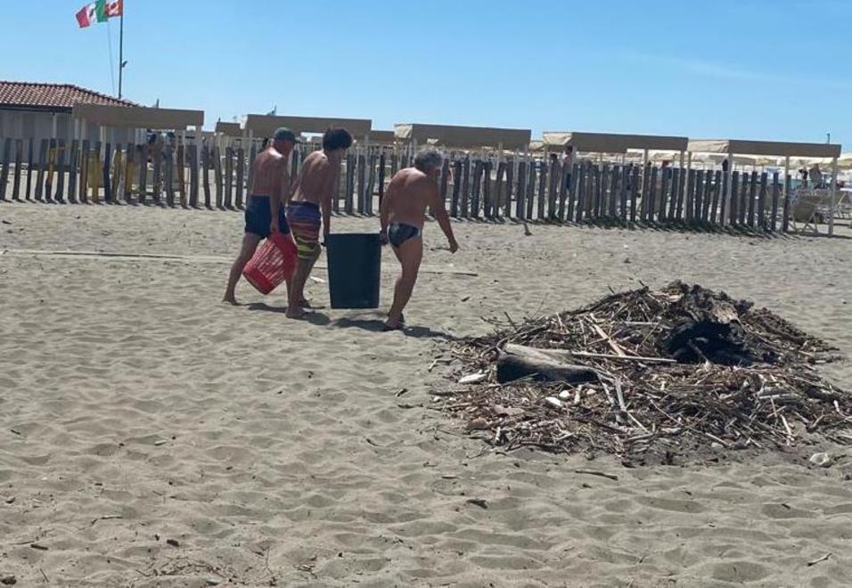 A Massa la spiaggia libera è piena di sporcizia, la puliscono i turisti con grossi secchi 