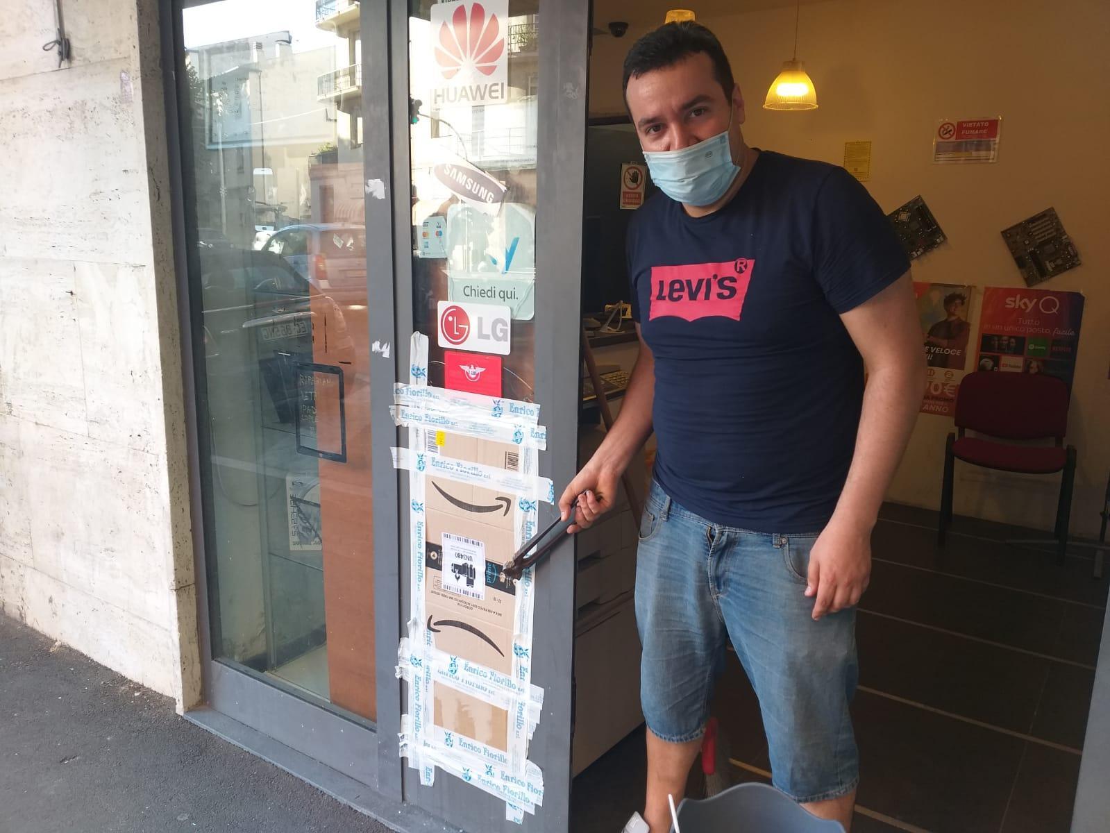 Matteo Ritorto con in mano le tronchesi lasciate dai ladri e a destra la vetrata rotta