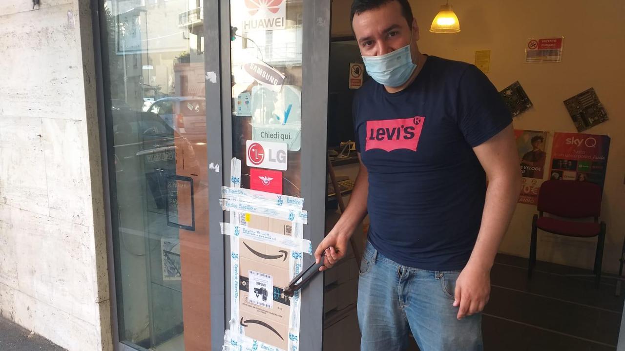 Matteo Ritorto con in mano le tronchesi lasciate dai ladri e a destra la vetrata rotta