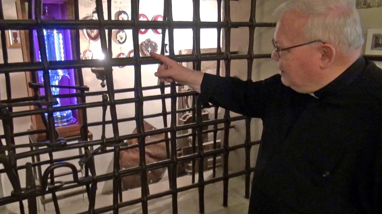 Monsignor Carlo Stancari indica le nappe custodire nella basilica delle Carceri