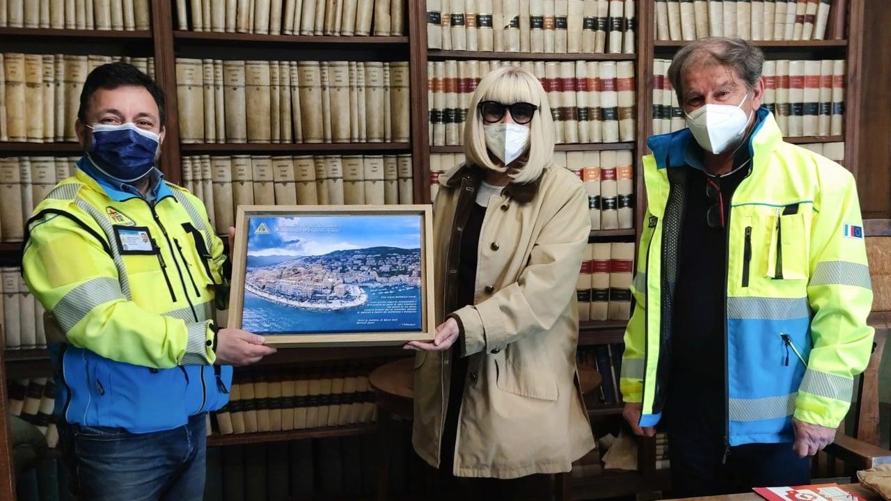 Raffaella Carrà durante l'incontro in occasione della donazione della palestra, mentre riceve in regalo una foto panoramica di Porto Santo Stefano