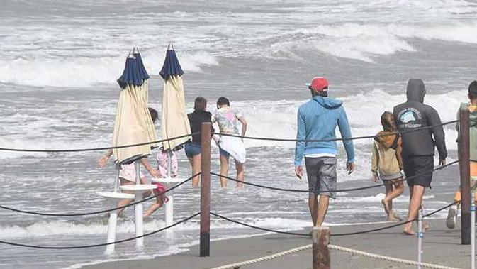 Spiaggia flagellata e ombrelloni in mare