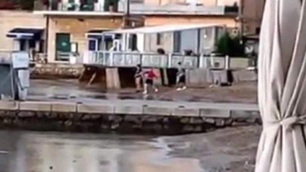 Un fermo immagine che riprende i tre giovani mentre lanciano i sassi contro le barche