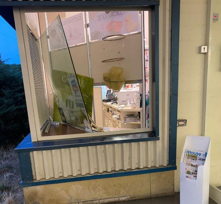 Distrugge con un tombino la vetrata della farmacia 