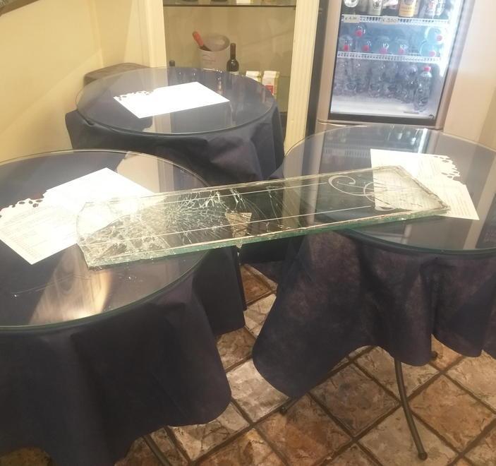 Il vetro scardinato all’ingresso del bar