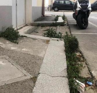 Marciapiedi rotti e pieni di erbacce nel quartiere Senzuno (Foto Giorgio)