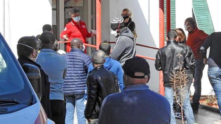 Persone in fila fuori dalla sede della Croce Rossa