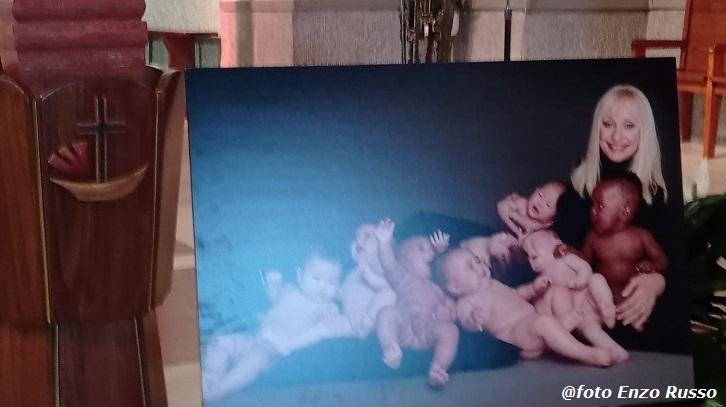 La fotografia di Raffaella Carrà che accompagna le sue ceneri, nella chiesa di Porto Santo Stefano, per l'ultimo saluto dell'Argentario alla regina dello show (foto Enzo Russo)