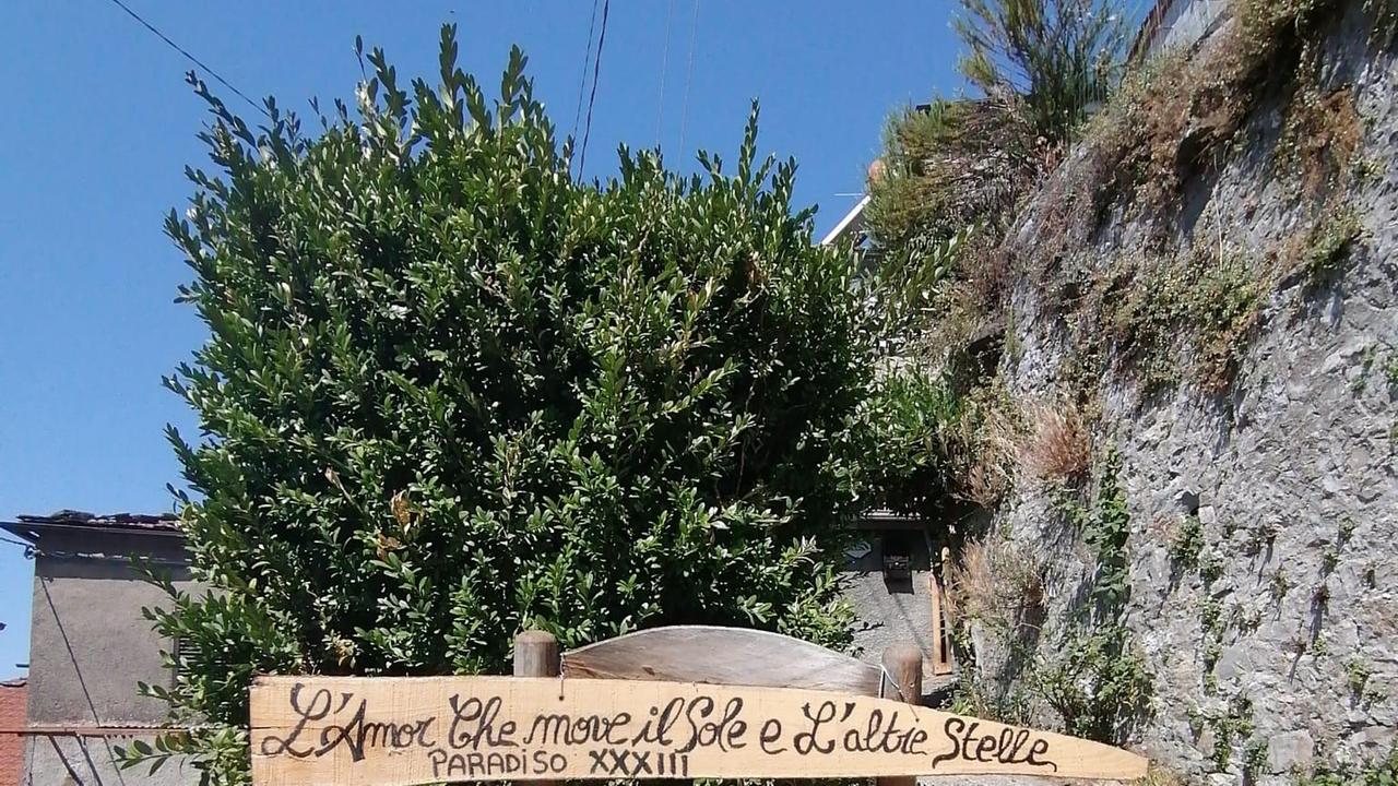 Una vecchia sedia nel borgo di Montefegatesi con i versi famosi dell’ultimo canto del Paradiso