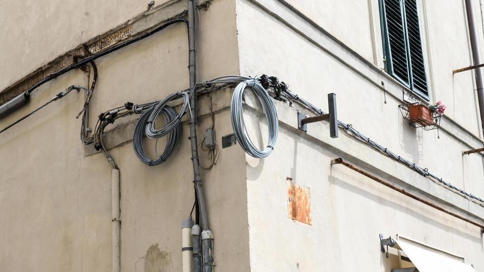 Cavi aggrovigliati di fibra ottica appesi alle facciate: è protesta