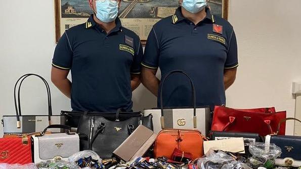 Nascoste sotto la sabbia c’erano etichette e borse false