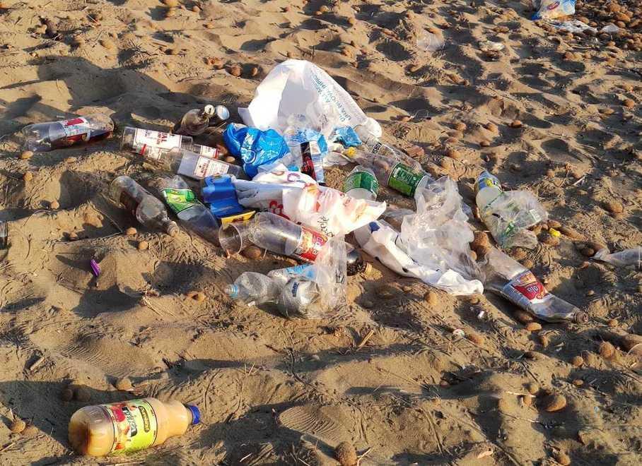 Vetro, plastica e una tenda abbandonati sulla spiaggia 