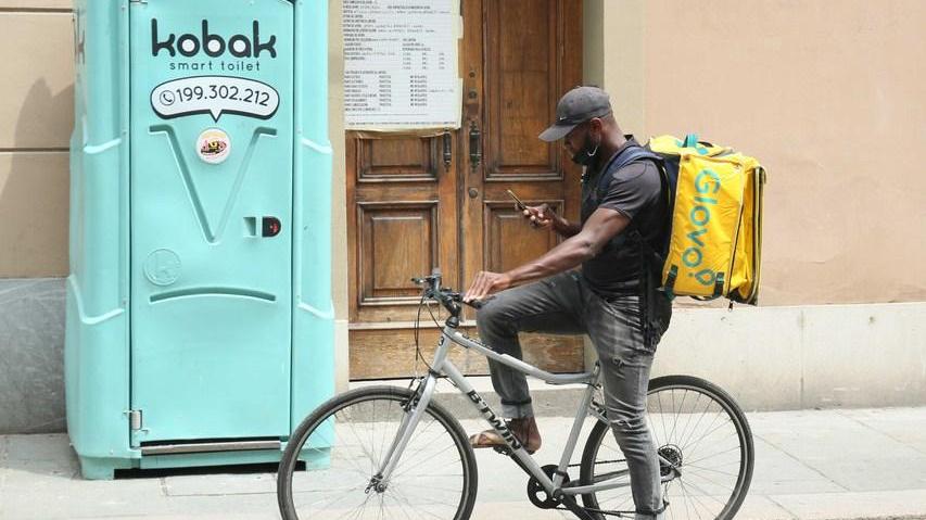 Un fattorino al lavoro in una città italiana sotto il sole