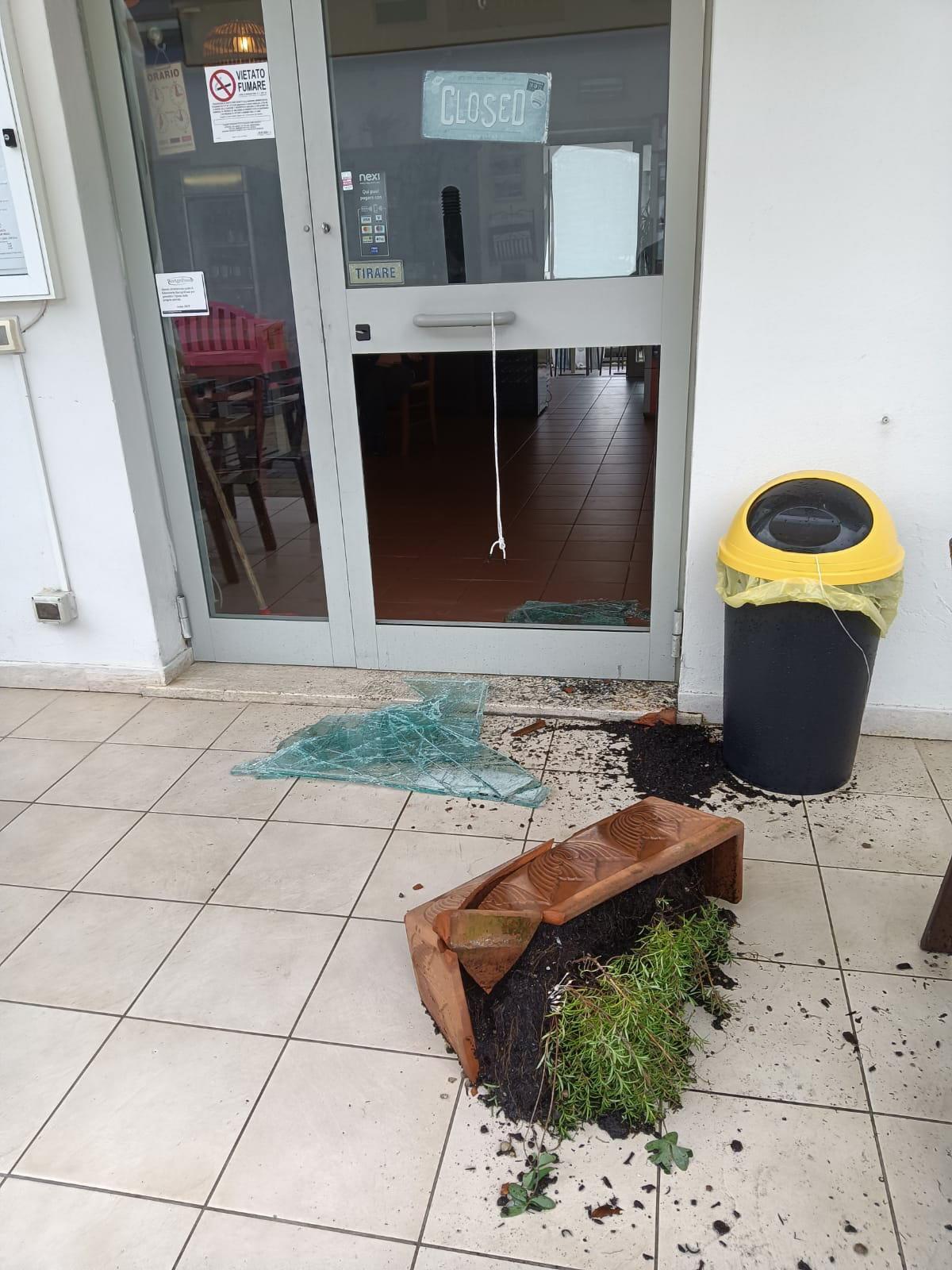 La porta del ristorante "Da Torelli" danneggiata dal ladro con un vaso di fiori