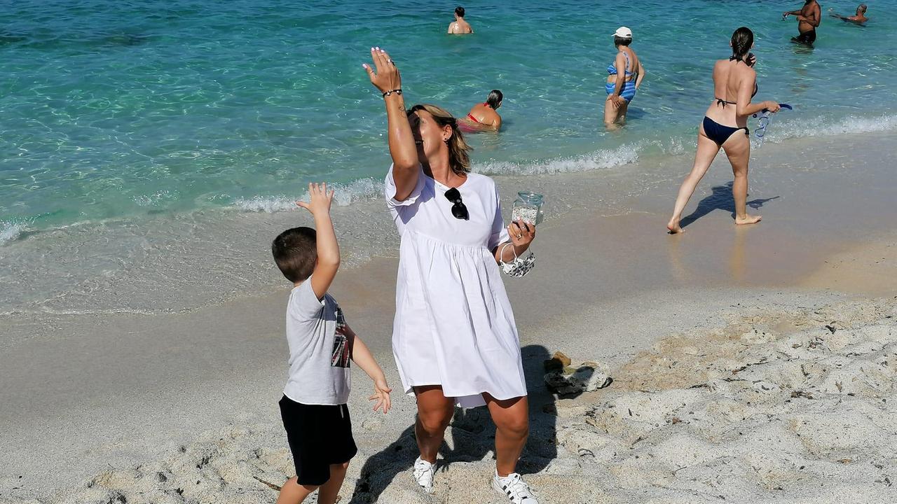 Adriano e la sua mamma restituiscono al mare di Is Aruttas i sassolini portati via tanti anni fa