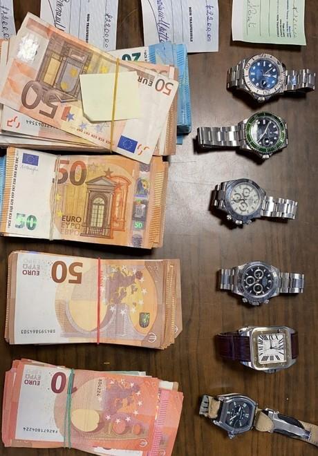 Parte dei soldi e degli orologi sequestrati dai carabinieri e dalla guardia di finanza