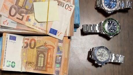 Parte dei soldi e degli orologi sequestrati dai carabinieri e dalla guardia di finanza