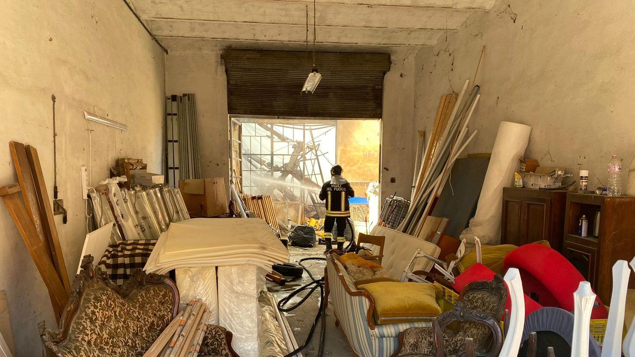 Un vigile del fuoco mentre spegne l'incendio nella tappezzeria (foto Franco Silvi)