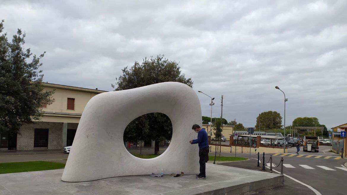 Lo scultore Kan Yasuda mentre pulisce la propria scultura alla stazione di Pietrasanta