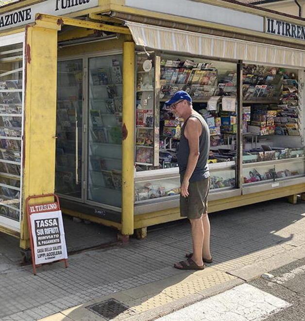 Un cecinese mentre legge la locandina del Tirreno esposta davanti ad un'edicola (foto Falorni/silvi)
