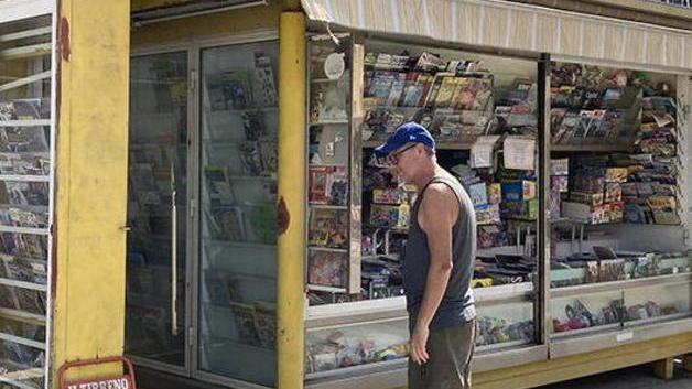 Un cecinese mentre legge la locandina del Tirreno esposta davanti ad un'edicola (foto Falorni/silvi)