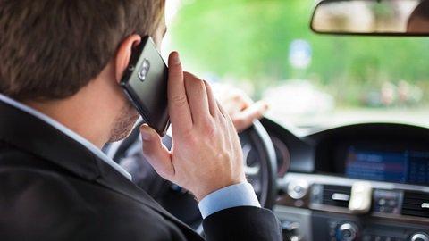 Una persona alla guida col cellulare (foto d'archivio)