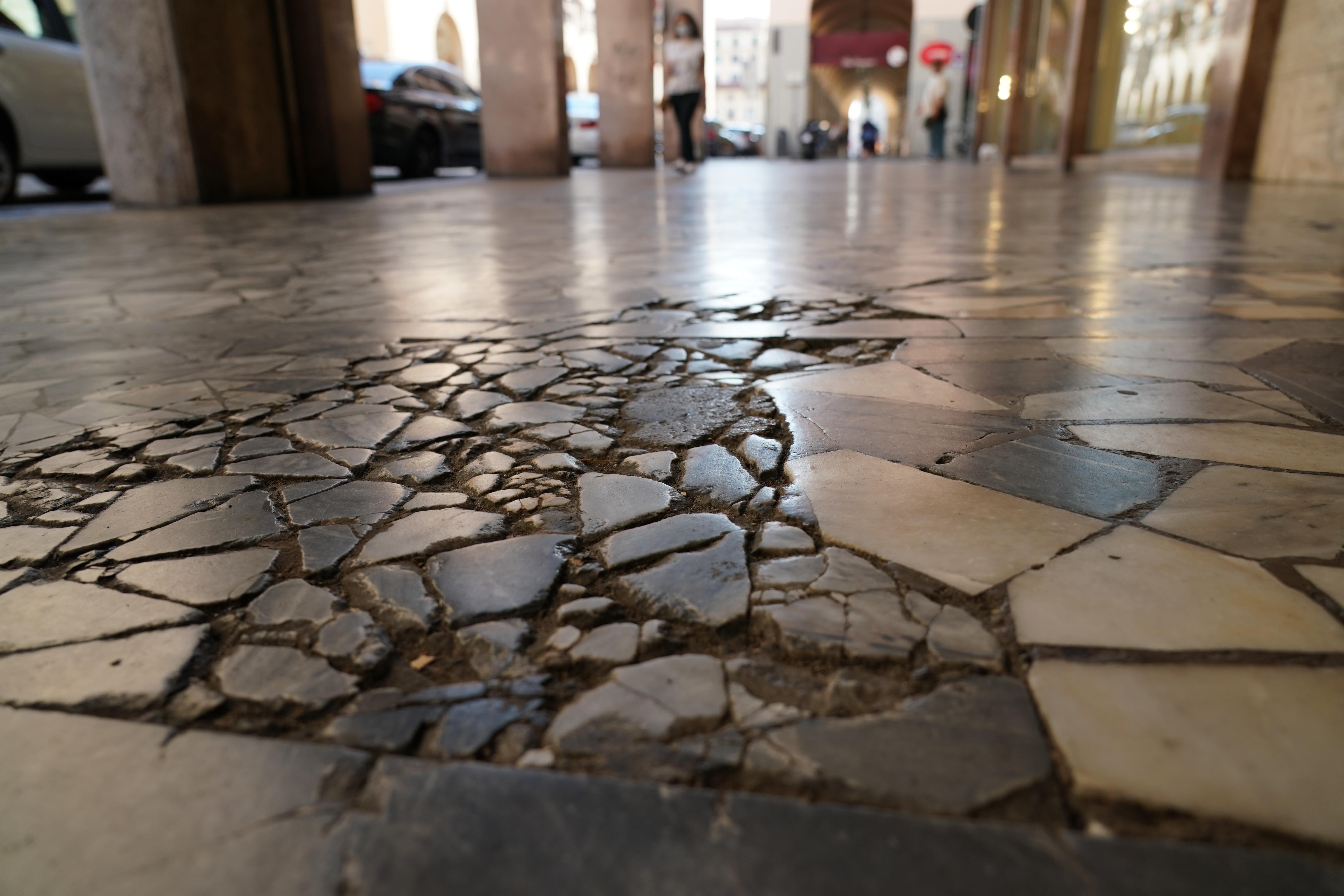 La pavimentazione ormai degradata sotto i portici di via Grande: la Giunta ha stanziato oltrre 500 mila euro per il concorso di progettazione