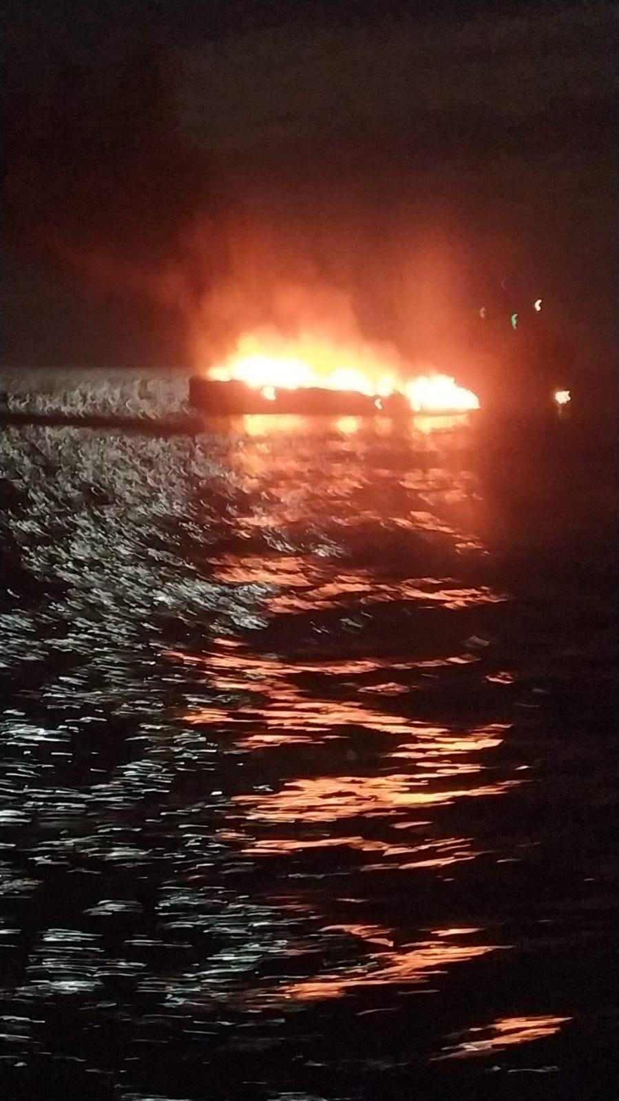 L'imbarcazione a fuoco alla deriva poco prima di colare a picco