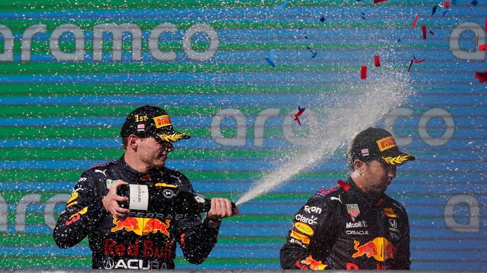 ) I festeggiamenti di Max Verstappen sul podio con il compagno di scuderia Perez
