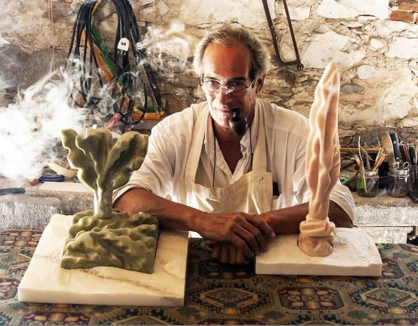 Pier Giorgio Balocchi con due sue sculture e con l’immancabile pipa tra i denti