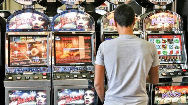 Un giocatore davanti una slot (foto d'archivio)