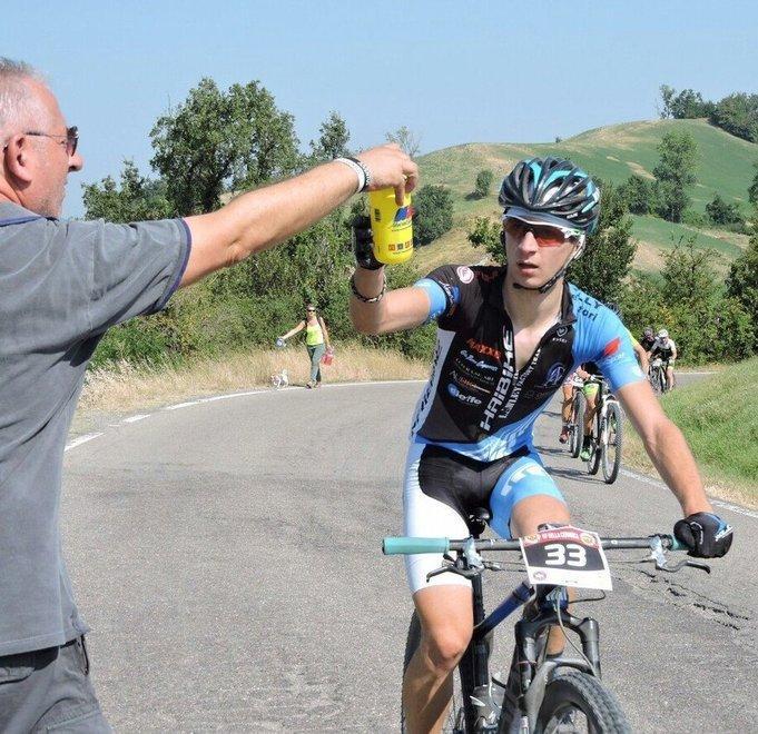 Simone Pardini mentre raccoglie la borraccia che gli viene passata dal padre