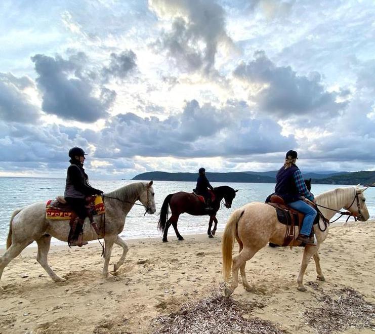 Cavalieri e cavallerizze durante la passeggiata a cavallo sulla spiaggia di Lido di Capoliveri, teatro dell’iniziativa