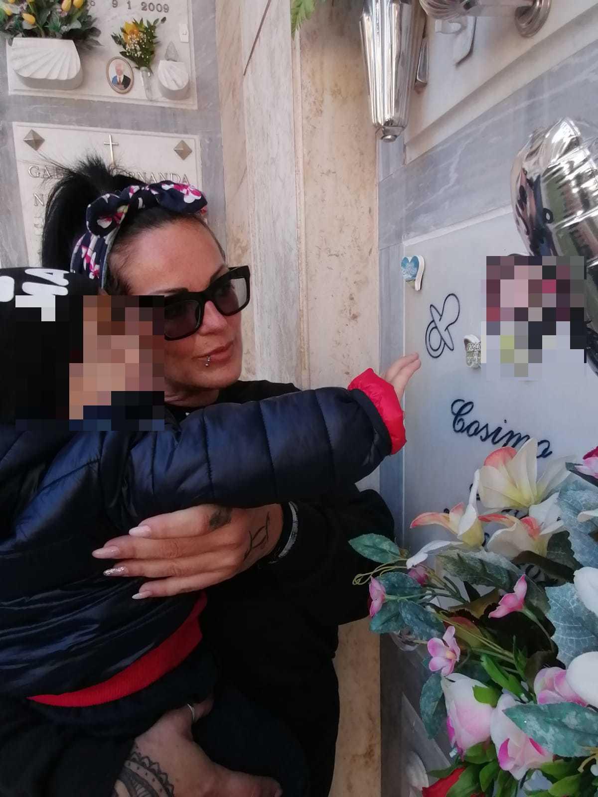 La mamma con il figlio davanti alla tomba del bambino morto