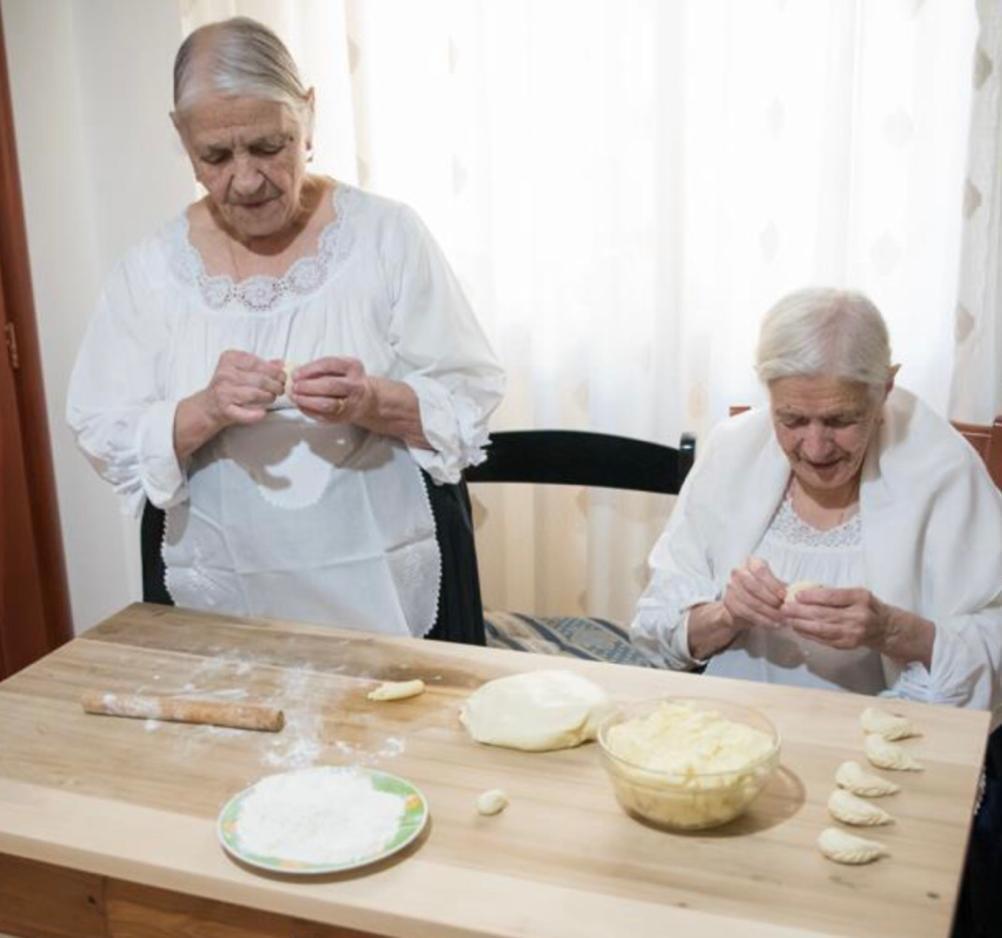Ida e Assunta Podda (seduta), rispettivamente 93 e 100 anni, preparano i culurgiones per l’Accademia Italiana della Cucina