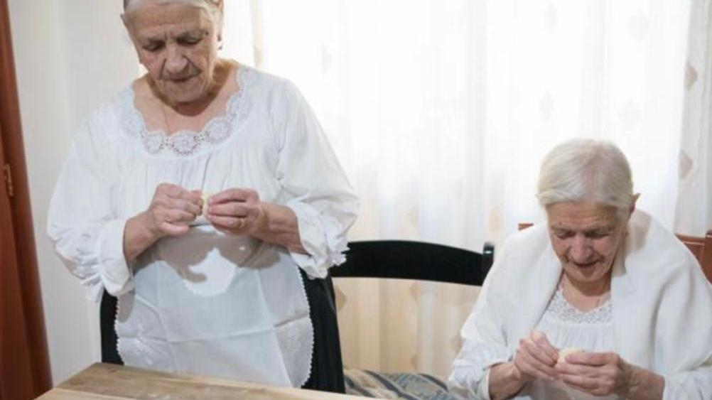 Ida e Assunta Podda (seduta), rispettivamente 93 e 100 anni, preparano i culurgiones per l’Accademia Italiana della Cucina