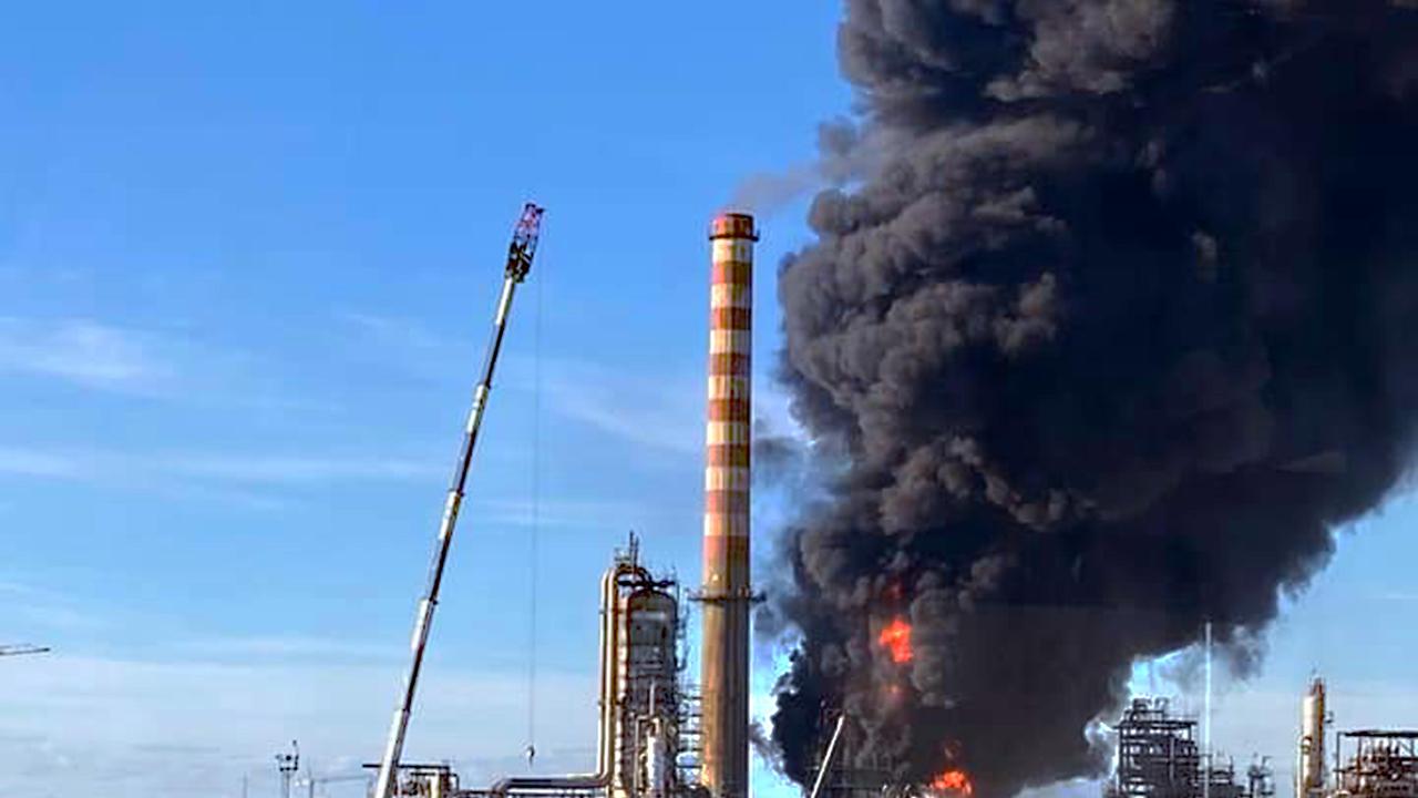 le fiamme attorno al forno all’interno della raffineria e la grande colonna di fumo nero che si alza dall’incendio