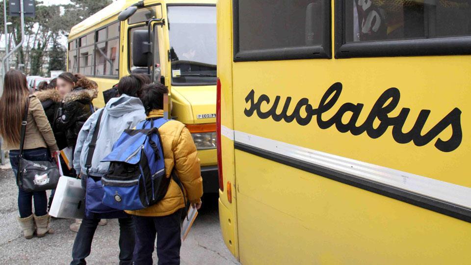 Bambini davanti a uno scuolabus (foto d’archivio)