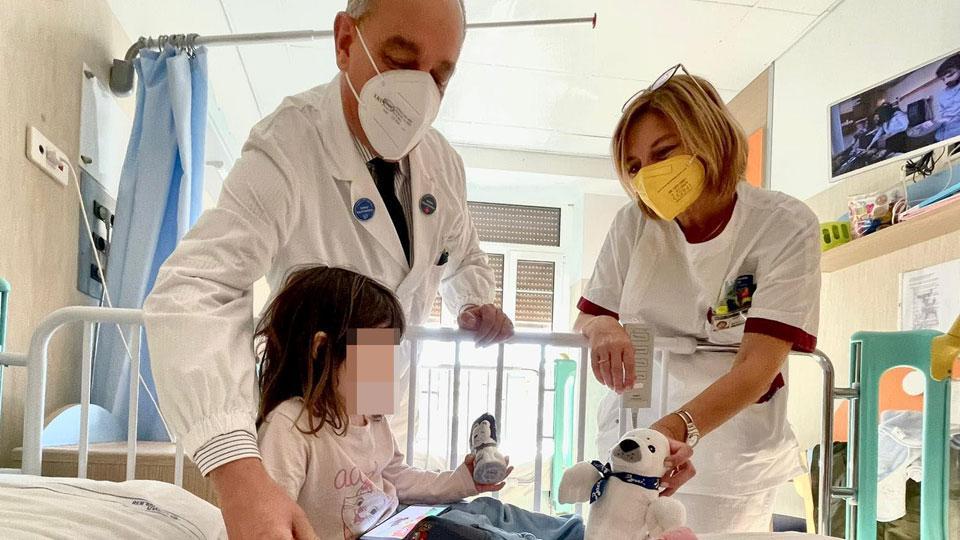 Il primario Danieli con la coordinatrice infermieristica Wüst consegna un dono a una bambina (stefanini)