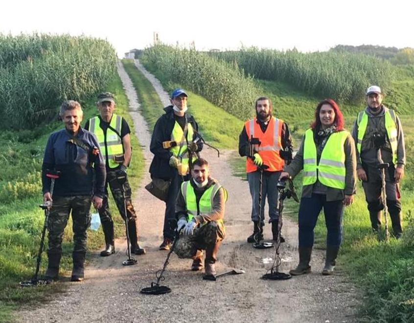 Volontari e metal detector in spiaggia o nel bosco a caccia di oggetti smarriti 