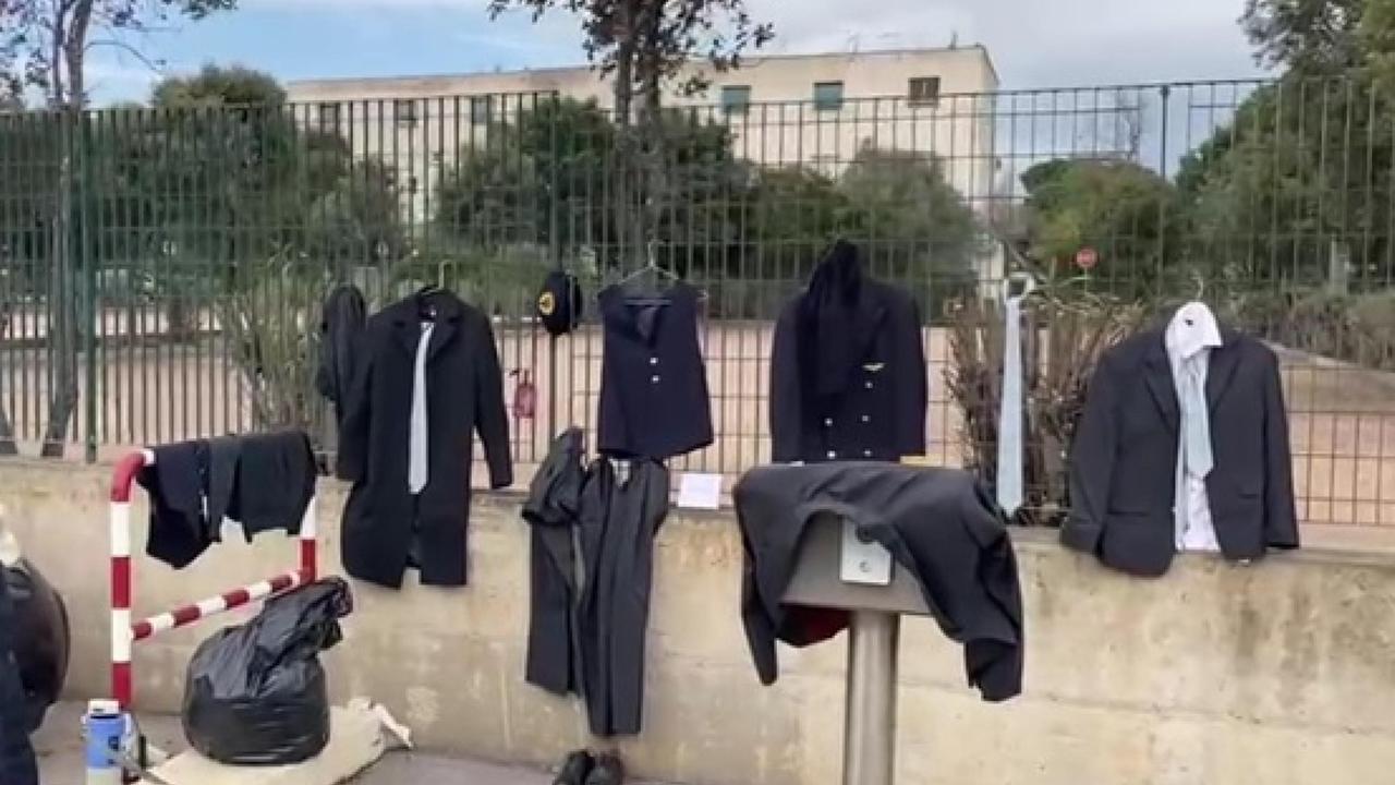 Le divise di Air Italy appese sulla recinzione dell'aeroporto (foto vanna sanna)
