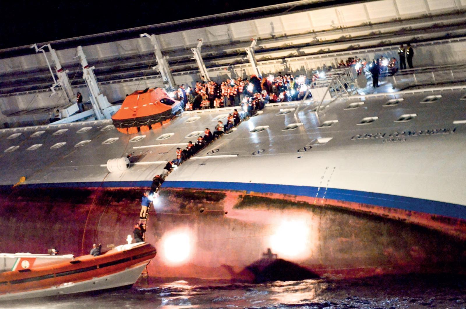 I passeggeri abbandonano la nave usando la biscaggina (foto Massimo Sestini)